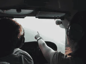 un homme et une femme dans le cockpit d'un hélicoptère. La femme montre le chemin.